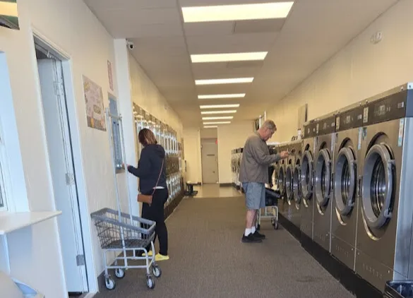 Customers using high-capacity washers at Tumblerama's modern laundromat.